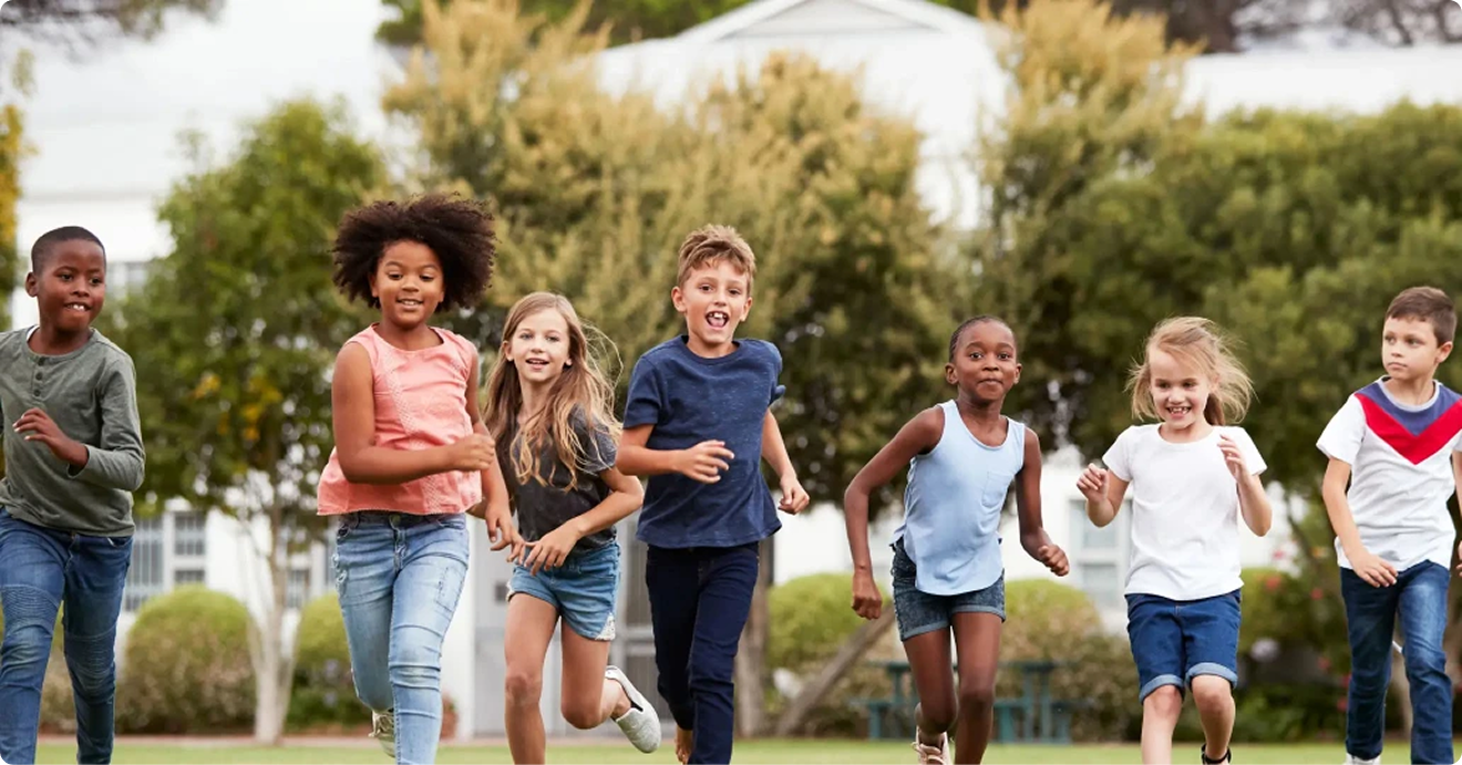 A group of children running joyfully in a park, showcasing energy and happiness in a natural setting