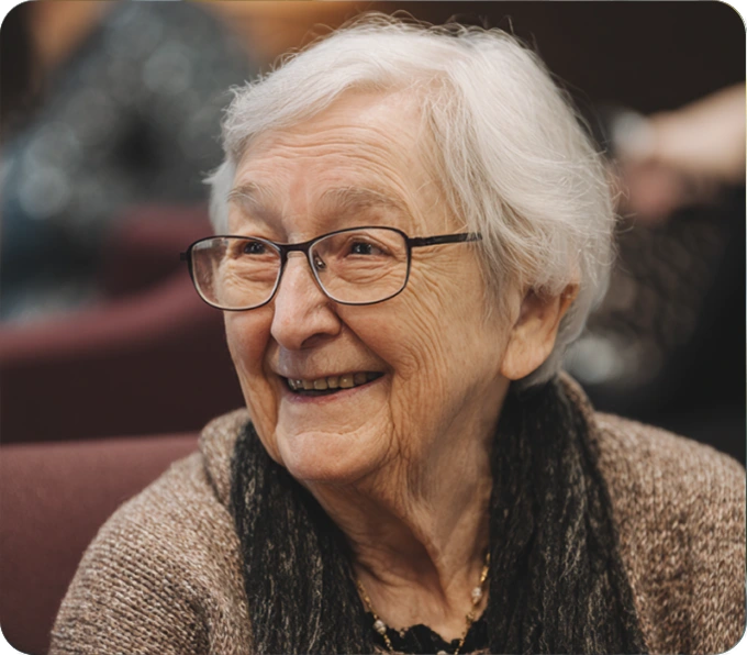 Elderly woman with glasses smiling warmly showing independence confidence from KISA automatic fall detection protection